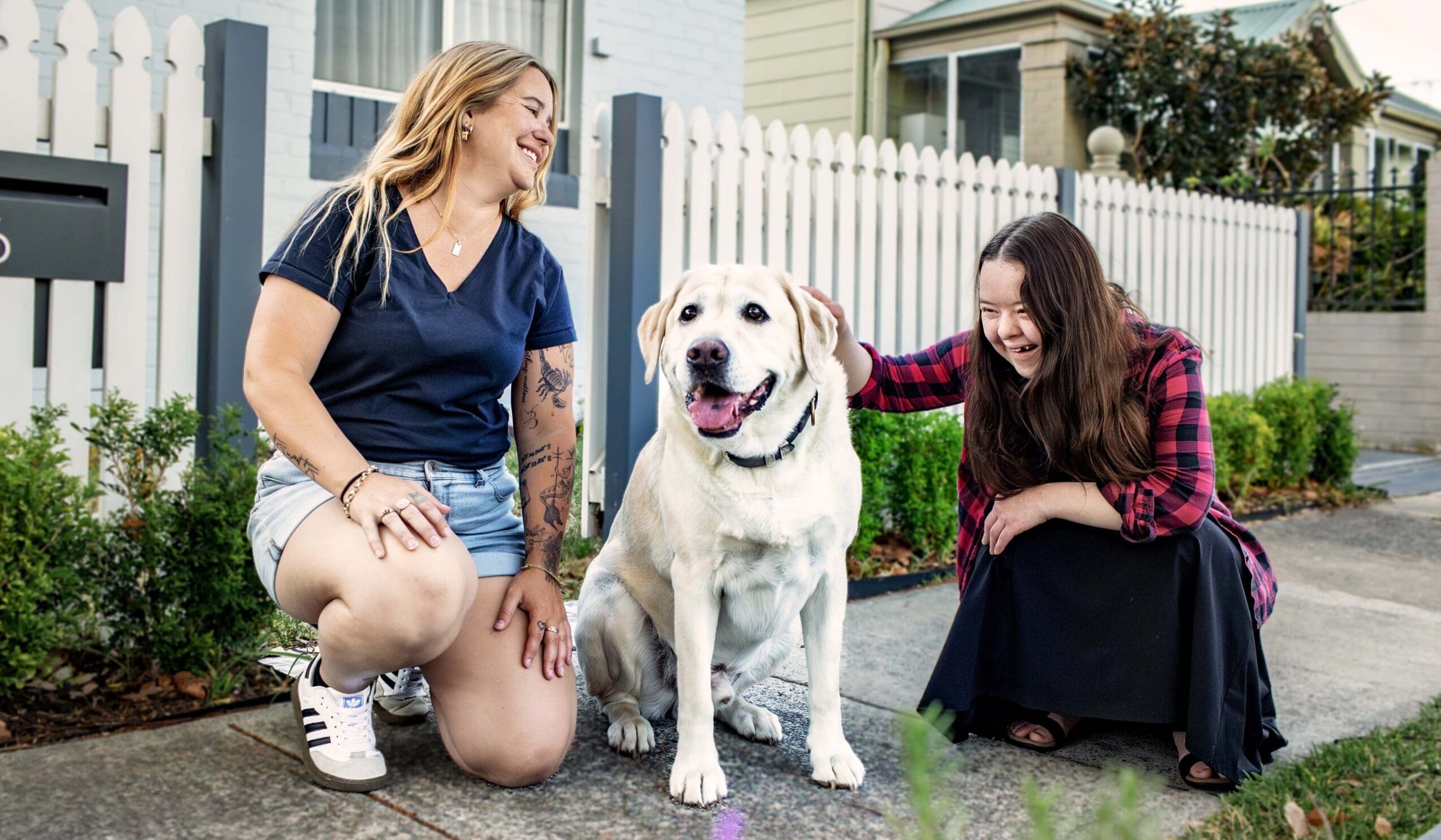A support worker and SIL client enjoying a moment with a dog.